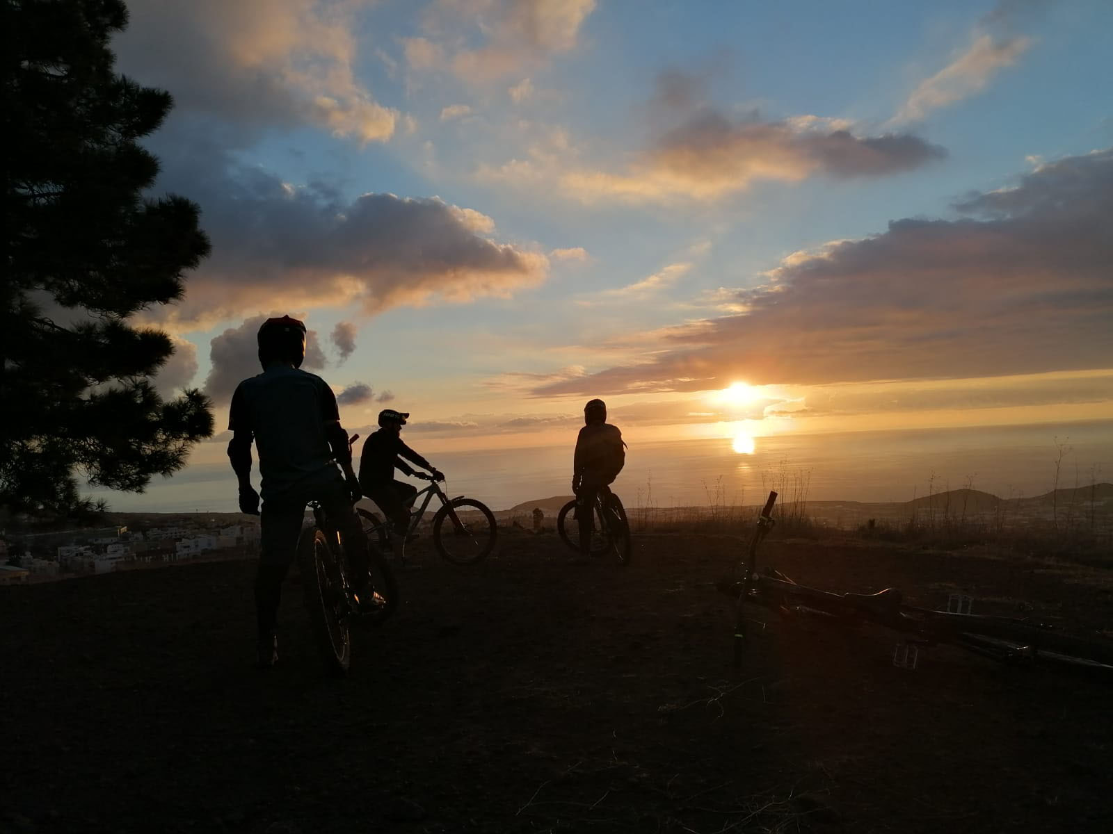 Eine Gruppe Mountainbiker genießt den Sonnenuntergang mit Blick auf den Ozean nach einem super Bike Tag auf La Palma (Kanarische Inseln)
